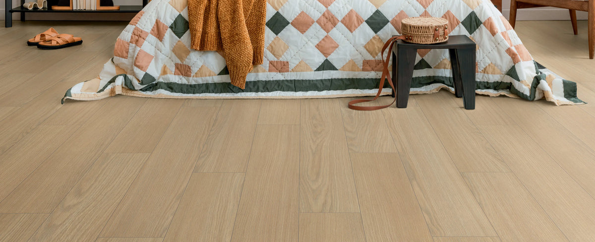 Wooden flooring with a quilt draped over a chair in the background