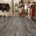 Interior of a clothing store with wooden flooring and racks of clothes.