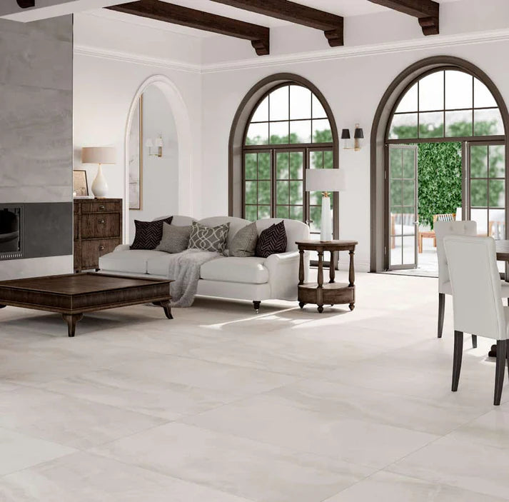 Modern living room with white sofa, wooden coffee table, and large windows.