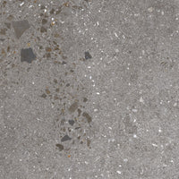 Close-up of a textured concrete surface with small stones and variations in gray tones.