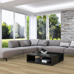 Modern living room with a gray sectional sofa, coffee table, and large windows.