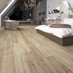 Modern bedroom with wooden flooring, bed, and bathroom.